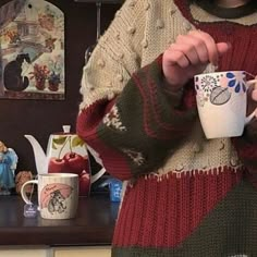 a woman is holding a cup in her hands