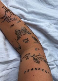 a person laying in bed with tattoos on their arm