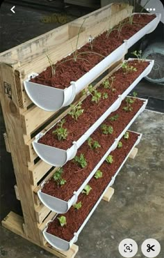 three wooden pallets filled with plants on top of each other and the bottom shelf is made out of wood