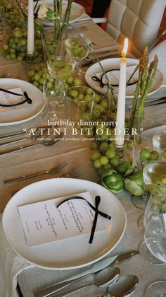 the table is set with plates, silverware and candles for an elegant dinner party