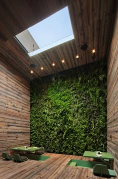 a room with wooden walls and green plants on the wall