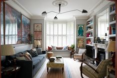 a living room filled with lots of furniture and windows covered in shuttered glass shades