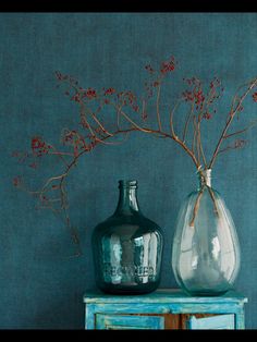 two vases sitting on top of a blue table