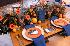 an orange and blue table setting with place settings