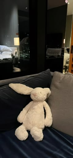 a white stuffed rabbit sitting on top of a couch