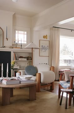 a living room filled with furniture and a fire place in front of a large window