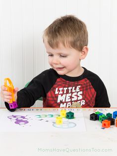 a young boy playing with toys at a table