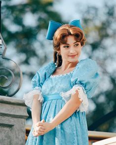 a woman in a blue dress posing for the camera