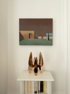 two pairs of shoes sitting on top of a white table next to a book shelf