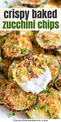 crispy baked zucchini chips on a plate with sour cream and parsley