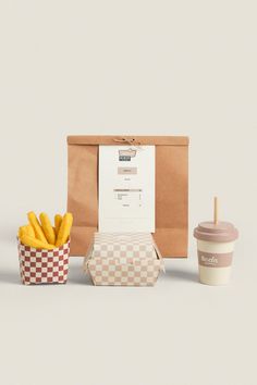 a paper bag with french fries and a cup of coffee next to it