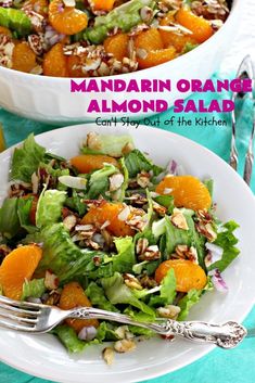 mandarin orange almond salad in a white bowl on a blue tablecloth with silverware