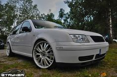 a silver car parked on top of a grass covered field