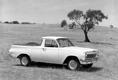 an old car parked in the middle of a field