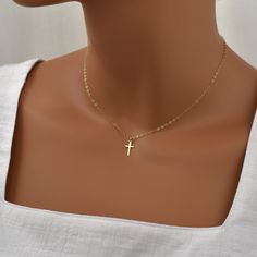 Simple Gold Cross Necklace for Women. This sweet and simple cross necklace is made with high-quality 14K gold filled. Dainty, lightweight, and feminine, it goes effortlessly with any outfit, casual or formal. This classic necklace makes a fantastic gift for any woman or girl on your list. Not including the loop, the cross measures approximately 1/2 inch high, and 1/4 inch wide (about 12mm X 7mm).  What is Gold Filled? Gold filled jewelry has a layer of solid gold that is 100 times thicker than that of gold plated jewelry. It is hypoallergenic, resistant to tarnish, and will not chip or fade over time. Gold filled has an appearance nearly identical to solid gold, but with a more affordable price. It is highly durable and with proper care will last a lifetime. Browse my shop: ALLDANAE.etsy.c Delicate Gold Cross Necklace, Gold Cross Necklace For Women, Simple Cross Necklace, Cross Necklace Simple, Cross Necklace For Women, Christian Necklace, Simple Cross, Golden Chain, Gold Cross Necklace