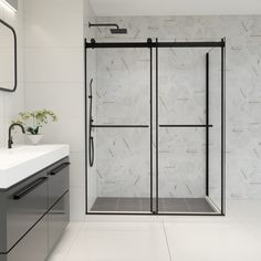 a white bathroom with a glass shower door