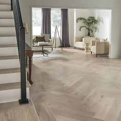 a living room filled with lots of furniture and a staircase leading up to the second floor