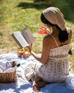 a woman sitting on the ground reading a book