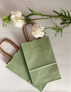 two paper bags with flowers on them sitting next to each other