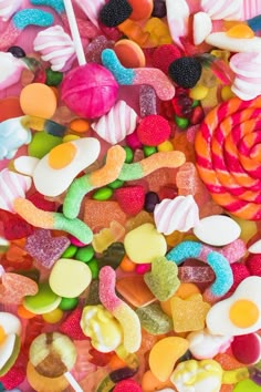 colorful candies and lollipops are scattered on top of each other