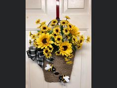 a door hanger with sunflowers on it and a checkered ribbon hanging from the front