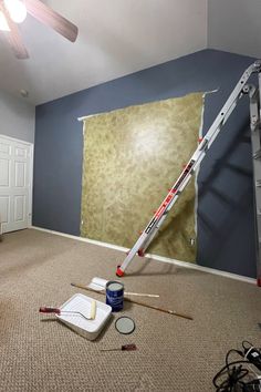 an empty room with paint and tools on the floor