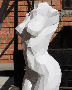 a large white bear statue sitting in front of a brick building