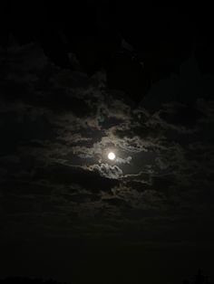 the full moon is shining brightly in the dark night sky with clouds and trees below