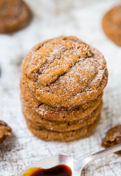 a stack of cookies sitting on top of a table next to a spoon with syrup