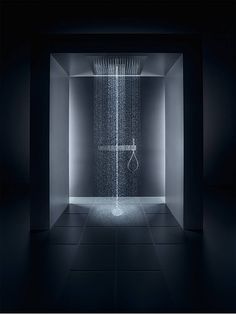 a shower head in the middle of a dark room with water coming out of it