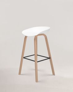 a white stool with wooden legs on a grey background