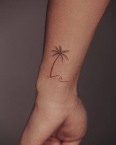 a small palm tree tattoo on the left wrist is shown in this image, it looks like