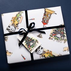 a present wrapped in wrapping paper with cartoon images on it, tied to a black ribbon