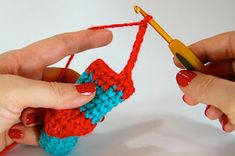 two hands are crocheting together to make an ornament for a doll