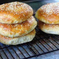 three sesame seed bagels cooling on a rack