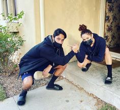 two people kneeling down on the steps in front of a house with their hands together