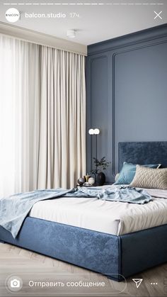 a bedroom with blue walls and white drapes on the window sill, along with a large bed