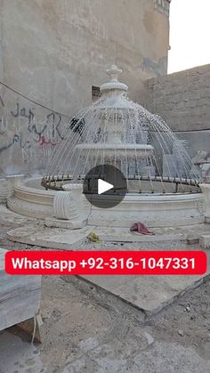 an old fountain with graffiti on it in the middle of a courtyard area that has been vandalized