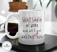 a white coffee mug with the words secret santa at work and all i got was this hug