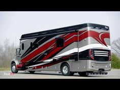 a silver and red motor home parked in a parking lot