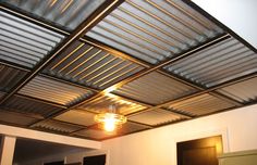 a room with a ceiling made out of metal sheeting and a light fixture hanging from the ceiling