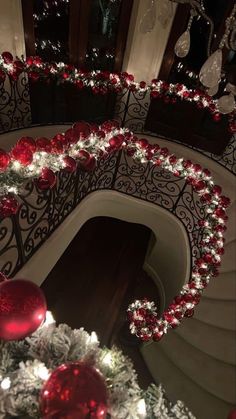 a staircase decorated for christmas with red and white ornaments