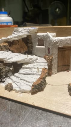 a model of a house made out of clay and rocks on top of a table