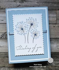 a blue and white card with dandelions on it