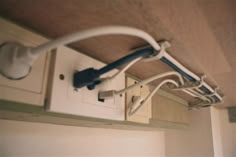 an electrical outlet attached to the ceiling in a room with white cabinets and cupboards