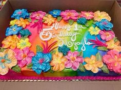 a birthday cake decorated with flowers in a box