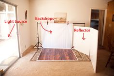 an empty room with white backdrop and wood flooring