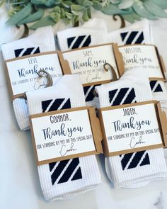 folded thank you cards with wedding rings on them sitting on a table next to greenery