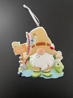 a christmas ornament with a gnome holding a fishing pole and fish on it