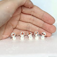 five tiny snowmen are in the palm of someone's hand